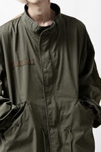 Load image into Gallery viewer, mastermind WORLD x ALPHA INDUSTRIES M-65 MODS COAT - CRAZY PANELED (OLIVE)